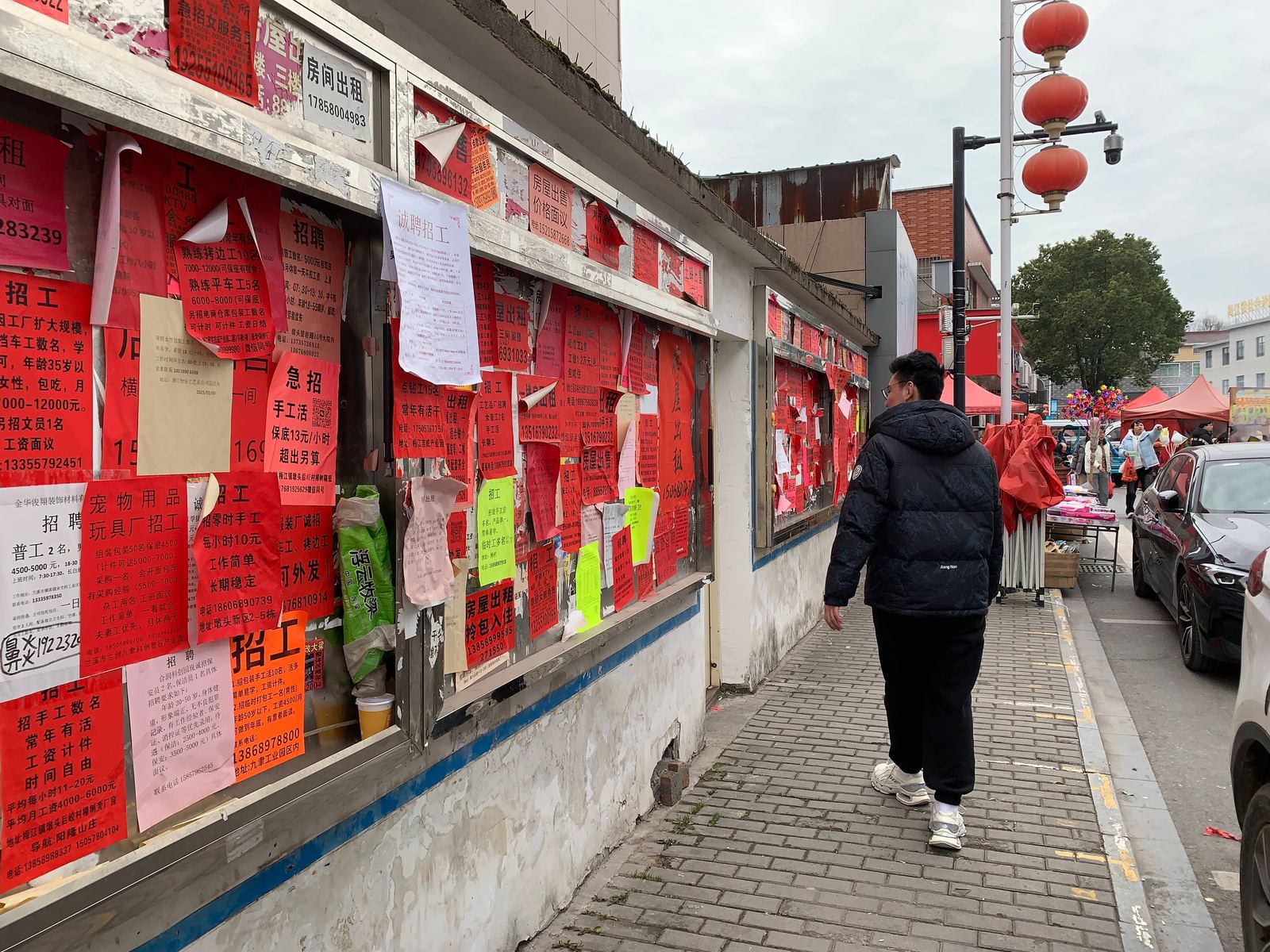 A street wall covered with red job and rental notices