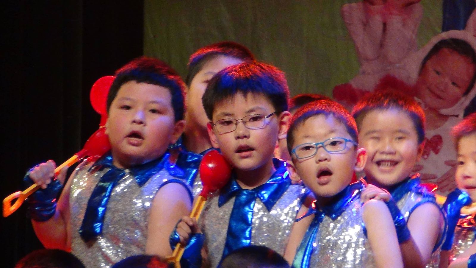 Close view of children singing on stage in matching costumes