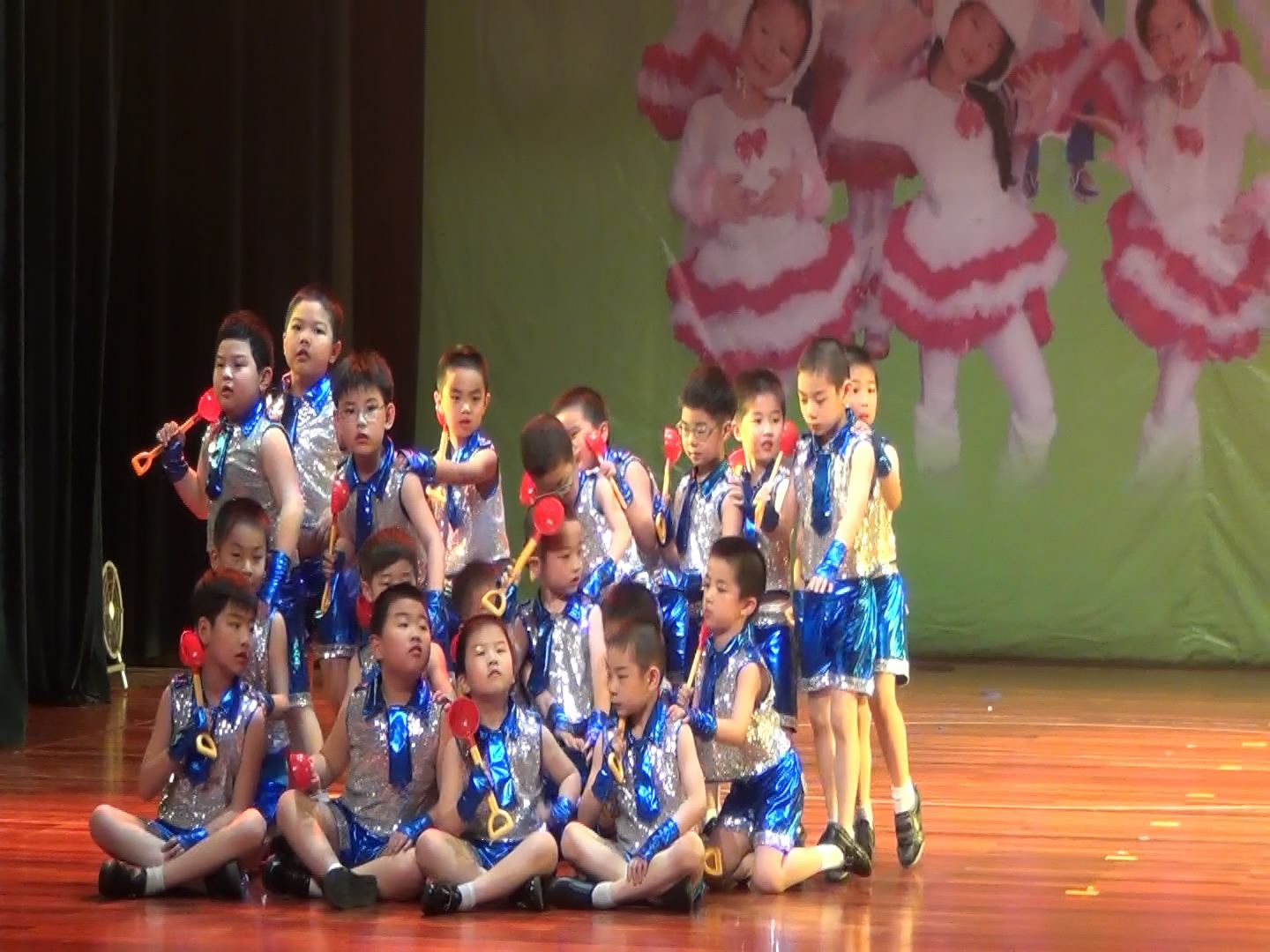 A full children's ensemble on a wooden stage
